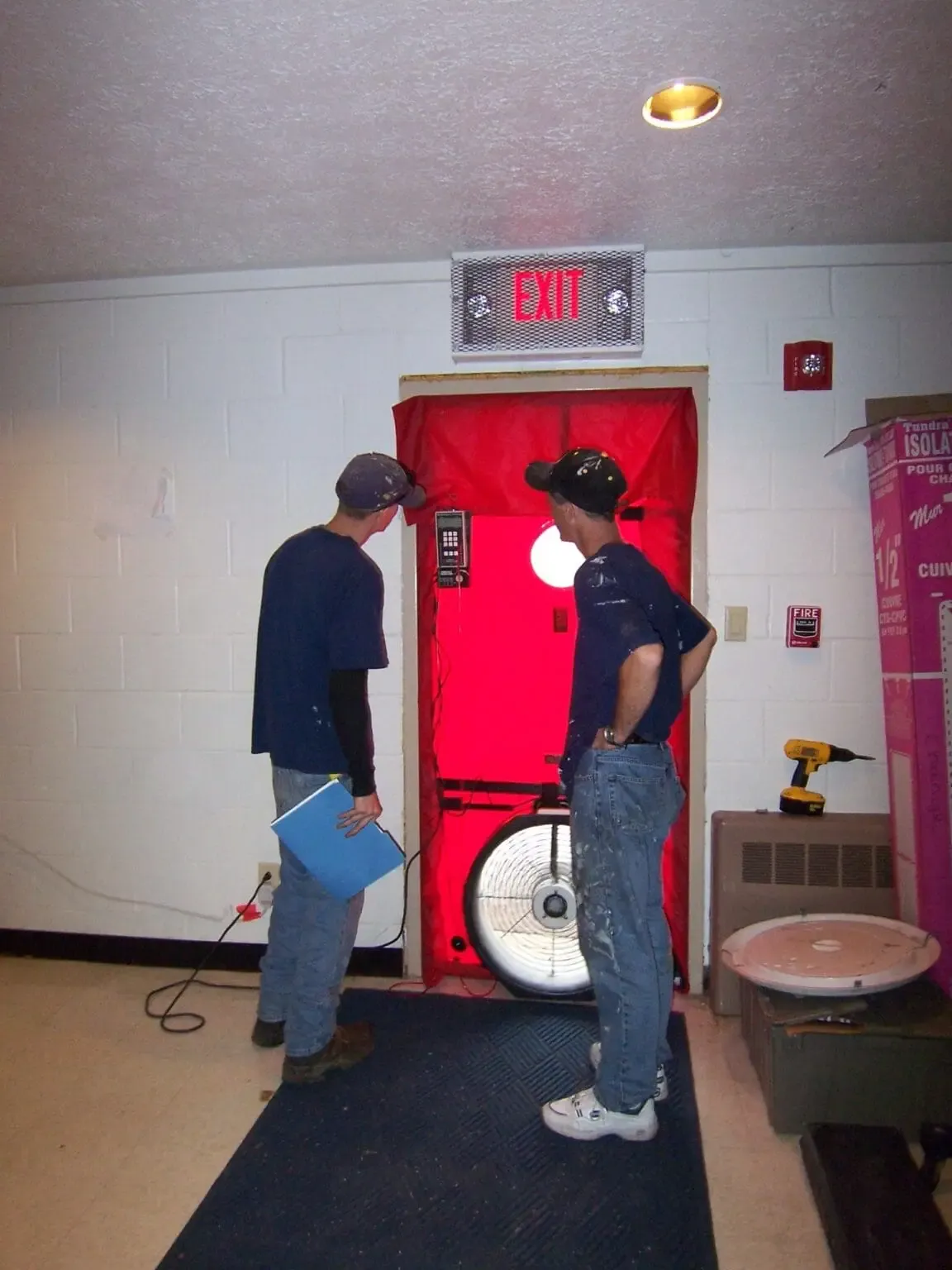 A crew member running a blower door test
